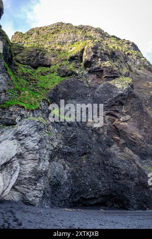 Grotta di Halsanefshellir fatta di colonne di basalto sulla spiaggia di sabbia nera di Reynisfjara, formazioni rocciose vulcaniche ricoperte di muschio, Islanda. Foto Stock