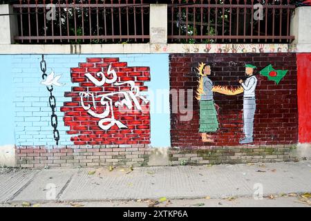 Una vista degli studenti dipingono graffiti su un muro lungo una strada per esprimere le loro voci dopo la caduta dell'ex primo ministro del Bangladesh Sheikh Hasina a Dhaka, Bangladesh, il 15 agosto 2024 Foto Stock
