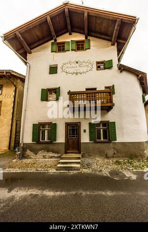 Una casa in stile Engadinese con persiane verdi e un balcone in legno intagliato reca l'iscrizione ‚Nicolaus Falletty 1826‘ sulla sua facciata nel borgo di Sot Tuer, Bergün Filisur, Grigioni. Sot Tuer, Bergün Filisur, Grigioni, Svizzera. Foto Stock