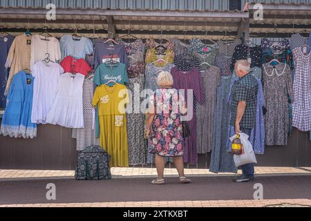 Due anziani russi, uomo e donna, stanno acquistando i vestiti al mercato locale del villaggio di Svoboda, Kursk Oblast, una regione della Russia sulla bo Foto Stock