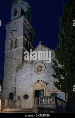 Crepuscolo a Cavtat, Croazia - mentre il sole tramonta, la luna sorge con la chiesa di San Nicola in primo piano Foto Stock