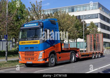 Nancy, Francia - Vista su un camion per trasporti pesanti blu e arancione Volvo FH 500 con rimorchio vuoto parcheggiato in una strada. Foto Stock