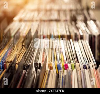 Collezione DJ in vinile. Sfondo poco focalizzato con ampio spazio di copia. Selezione di dischi in fila nel negozio di musica, dal rock alla danza fino all'EDM. Foto Stock