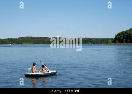 Zwei Jungs sitzen mit Paddeln auf einer Luftmatratze und treiben um die Mittagszeit entspannt auf dem Rheinsberger SEE nel Meclemburgo-Vorpommern.  7R32953 *** due ragazzi si siedono con le pagaie su un materasso ad aria e galleggiano rilassati sul lago Rheinsberg nel Meclemburgo-Vorpommern all'ora di pranzo 7R32953 Foto Stock