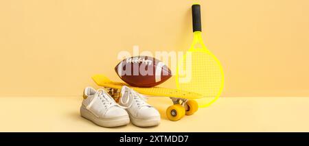 Diverse attrezzature sportive e scarpe su sfondo beige Foto Stock