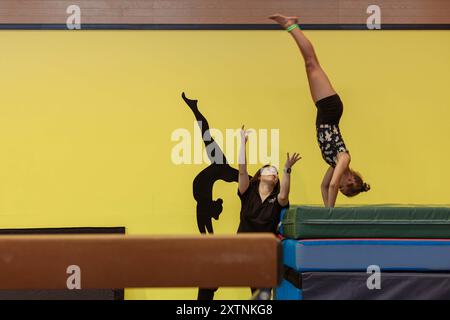 Camp Foster, Okinawa, Giappone. 8 agosto 2024. Il coach dell'Excellence Gymnastics Academy Senami Chinen vede una ginnasta che fa il salto durante la First Encounter Excellence Clinic al Gunners fitness Center, Camp Foster, Okinawa, Giappone, 8 agosto, 2024. i Marine Corps Community Services Okinawa invitarono gli allenatori di ginnastica degli Stati Uniti Katelyn Ohashi, Rhonda Schulz e Linda Johnson a condividere la loro esperienza a livello d'élite di ginnastica con i figli dei membri del servizio statunitense. Gli allenatori hanno allenato 50 ginnasti della Excellence Gymnastics Academy, della Typhoon Twisters Gymnastics Team e della Sports and Recreation Communit Foto Stock