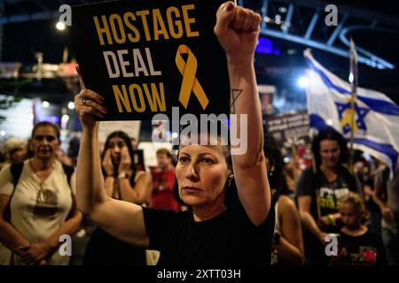 Israele. 15 agosto 2024. Una protesta con un cartello "accordo con gli ostaggi ora" la tiene in aria. Gli israeliani hanno manifestato con le famiglie degli ostaggi contro il primo ministro Benjamin Netanyahu, chiedendo un accordo immediato con gli ostaggi e il cessate il fuoco - mentre i negoziati per il cessate il fuoco a Gaza hanno luogo in Qatar. Tel Aviv, Israele. 15 agosto 2024. (Matan Golan/Sipa USA). Crediti: SIPA USA/Alamy Live News Foto Stock
