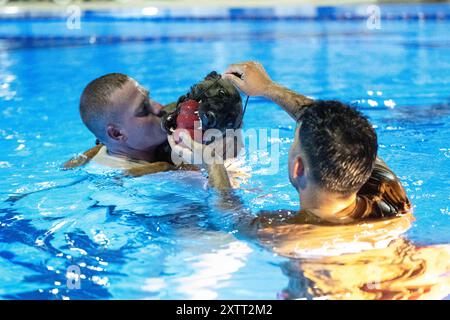 Luogo non divulgato. 6 agosto 2024. I maneggiatori di cani militari della U.S. Air Force lavorano con Ttommaso, un MWD, assegnato al 380th Air Expeditionary Wing, in una piscina durante un addestramento di familiarizzazione con l'acqua in un luogo sconosciuto all'interno dell'area di responsabilità dello U.S. Central Command, 4 agosto 2024. La formazione è volta a garantire che gli MWD siano efficienti ed efficaci durante il lavoro in qualsiasi situazione. (Credit Image: © U.S. Air Force/ZUMA Press Wire) SOLO PER USO EDITORIALE! Non per USO commerciale! Foto Stock