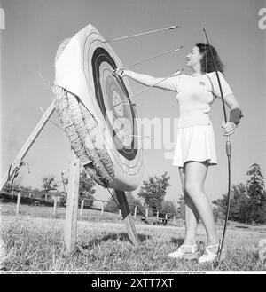 Tiro con l'arco negli anni '1940 La giovane attrice svedese Mimi Nelson davanti al bersaglio usato per sparare frecce. È vestita con il tipico pullover degli anni '1940 e una gonna. Svezia 1947 Rif. AD7-8 Foto Stock