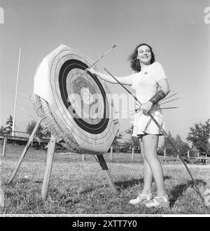 Tiro con l'arco negli anni '1940 La giovane attrice svedese Mimi Nelson davanti al bersaglio usato per sparare frecce. È vestita con il tipico pullover degli anni '1940 e una gonna. Svezia 1947 Rif. AD7-9 Foto Stock