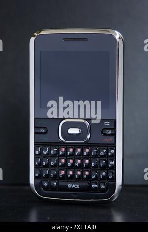 Telefono cellulare con tecnologia obsoleta isolato su sfondo nero Foto Stock