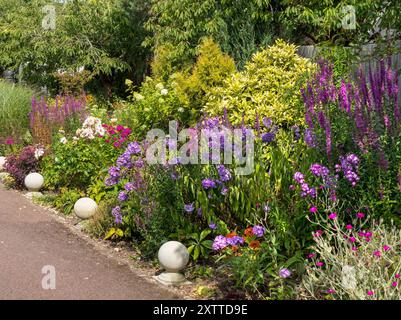 Attraente e profondo giardino interno con un mix di arbusti e piante perenni a luglio / agosto, Leicestershire, Inghilterra, Regno Unito Foto Stock