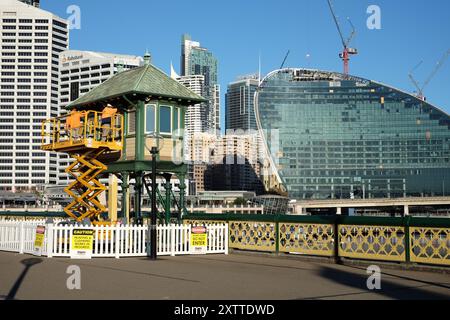 Gli uomini che lavorano sulla cabina di controllo sopraelevata sull'altalena di Pyrmont Bridge, Darling Harbour, Sydney The W Hotel sono in costruzione sullo sfondo Foto Stock