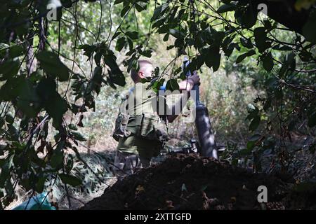 Non esclusiva: REGIONE DI DONETSK, UCRAINA - 14 AGOSTO 2024 - Un militare del 24° re Daniele di Galizia, brigata meccanizzata separata carica un mortaio Foto Stock