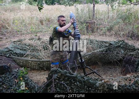 Non esclusiva: REGIONE DI DONETSK, UCRAINA - 14 AGOSTO 2024 - Un militare del 24° re Daniele di Galizia, brigata meccanizzata separata carica un mortaio Foto Stock