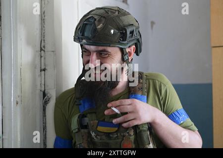 Non esclusiva: REGIONE DI DONETSK, UCRAINA - 14 AGOSTO 2024 - Un sorridente militare del 24° re Daniele di Galizia fuma di brigata meccanizzata separata Foto Stock