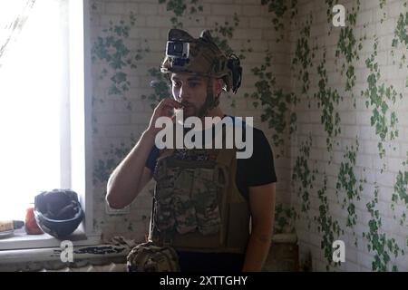 Non esclusiva: REGIONE DI DONETSK, UCRAINA - 14 AGOSTO 2024 - Un militare del 24° re Daniele di Galizia, brigata meccanizzata separata fuma un sigaro Foto Stock