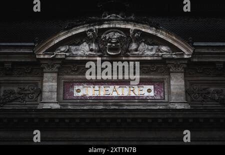 La foto cattura la facciata cupa e scura del Teatro di Lione, mostrando la sua superba architettura con statue intricate intagliate. Foto Stock