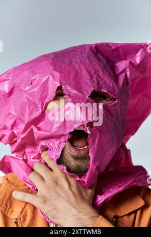 Un uomo lotta per respirare, il suo viso parzialmente coperto da un sacchetto di plastica rosa. Foto Stock