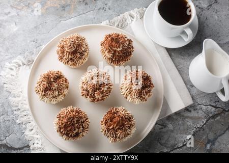 Cupcake tiramisù con glassa al mascarpone e primo piano del caffè sul piatto del tavolo. Vista dall'alto orizzontale Foto Stock