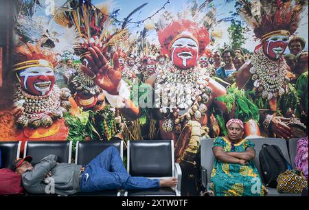 PAPUA NUOVA GUINEA, Port Moresby, aeroporto, immagine di Goroka o Hagen show, festival annuale di tibes / PAPUA NEUGUINEA, aeroporto di Port Moresby, Festival di Bilder vom e Treffen verschiedener Stämme a Trachten und Bemalung Goroka Show, wartende Passagiere Foto Stock