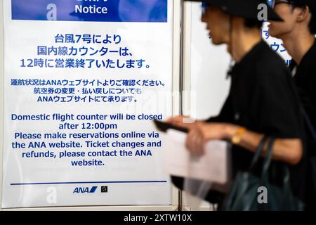 Tokyo, Giappone. 16 agosto 2024. I passeggeri passano un cartellone all'aeroporto Haneda di Tokyo, Giappone, 16 agosto 2024. Ampil, il settimo tifone dell'anno, ha colpito il Giappone venerdì, forzando la cancellazione dei servizi di trasporto pubblico. Crediti: Zhang Xiaoyu/Xinhua/Alamy Live News Foto Stock