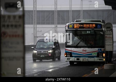 Tokyo, Giappone. 16 agosto 2024. I veicoli si muovono in mezzo alle piogge all'aeroporto Haneda di Tokyo, Giappone, 16 agosto 2024. Ampil, il settimo tifone dell'anno, ha colpito il Giappone venerdì, forzando la cancellazione dei servizi di trasporto pubblico. Crediti: Zhang Xiaoyu/Xinhua/Alamy Live News Foto Stock