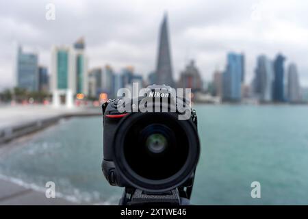 Nikon camera di fronte allo skyline di Doha. Messa a fuoco selettiva Foto Stock