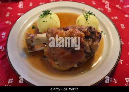 Cucina tedesca: Schweinshaxe (nocciolo di maiale arrosto) con gnocchi di patate a Rothenburg ob der Tauber, Germania Foto Stock