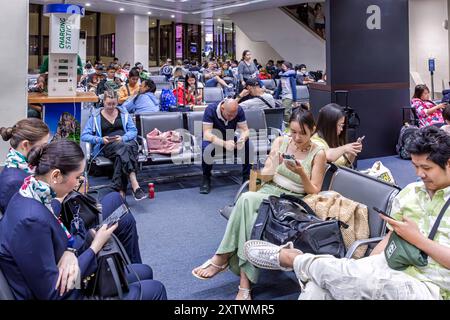 Passeggeri e equipaggio di volo nella sala partenze, Aeroporto Internazionale Ninoy Aquino, Manila, Filippine Foto Stock