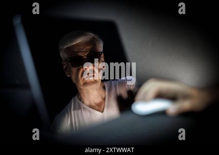 Tema: Cyberkriminalitaet. Ein Gesicht mit Sonnenbrille spiegelt sich in einem Bildschirm a Berlino, 09.08.2024. Berlin Deutschland *** argomento Cybercri Foto Stock