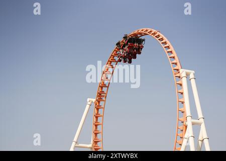Montagne russe sulla cima di un anello contro un cielo blu limpido. Foto Stock