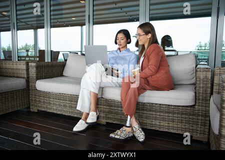 Due colleghi chiacchierano su una moderna terrazza sul tetto dell'ufficio, una con protesi alle gambe. Foto Stock