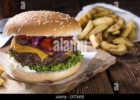 In casa hamburger con patatine fritte su un vecchio tavolo in legno Foto Stock