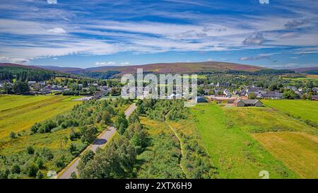 Tomintoul Moray Scozia cielo estivo blu sopra il villaggio e le colline coperte di erica viola Foto Stock