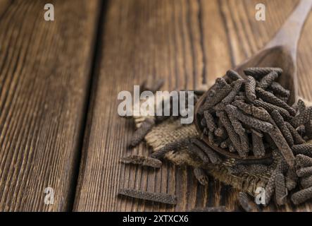 Pepe lungo (essiccata) su un vecchio tavolo di legno (messa a fuoco selettiva) Foto Stock