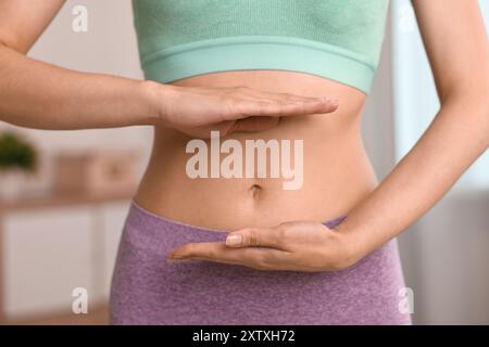 Digestione sana. Donna che tiene qualcosa vicino alla pancia dentro, primo piano Foto Stock