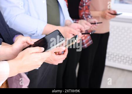 Persone che hanno smartphone con schermi vuoti all'interno, primo piano Foto Stock