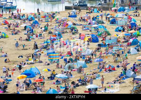 Lyme Regis, Dorset, Regno Unito. 16 agosto 2024. Meteo nel Regno Unito: Turisti e bagnanti affollano la spiaggia affollata della località balneare di Lyme Regis per crogiolarsi al caldo sole di agosto. Crediti: Celia McMahon/Alamy Live News Foto Stock