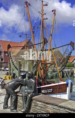 Porto di Neuharlingersiel, Germania del Nord, Frisia orientale, monumento dei pescatori di fronte ai pescherecci, Neuharlingersiel, bassa Sassonia, Federal R. Foto Stock