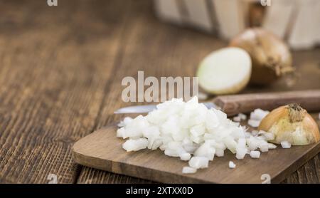 Cipolle bianche tritate su un vecchio tavolo di legno come primo piano dettagliato, messa a fuoco selettiva Foto Stock