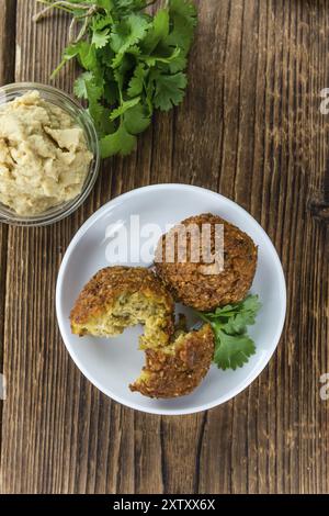 Falafel fatto in casa (primo piano, messa a fuoco selettiva) su sfondo in legno Foto Stock