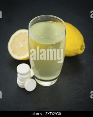 Alcune compresse di vitamina C su una lastra di ardesia come foto ravvicinata dettagliata, messa a fuoco selettiva Foto Stock