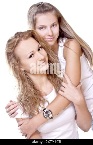 Due belle donne con T-shirt bianche su sfondo bianco isolate Foto Stock