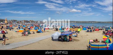 Panorama della spiaggia affollata in una calda giornata estiva a Weymouth, Dorset, Regno Unito il 16 agosto 2024 Foto Stock