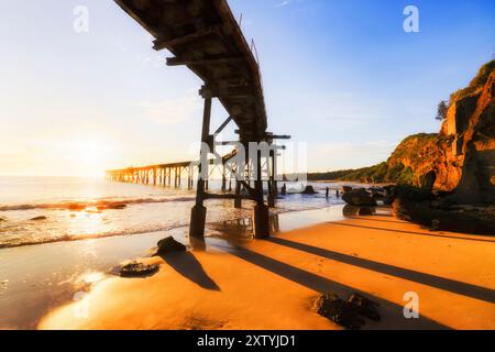 Storico molo in legno presso la spiaggia centrale di Camp, cittadina della baia di Catherine Hill, sulla costa del Pacifico in Australia. Foto Stock