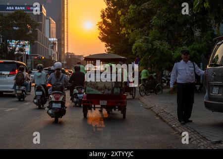 Phnom Penh in serata con il sole che tramonta sulle strade trafficate. Foto Stock