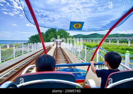 Samcheok, Corea del Sud - 29 luglio 2024: Vista posteriore di due passeggeri in partenza dalla stazione di Gungchon su una bici ferroviaria a quattro posti lungo il Samcheo Foto Stock