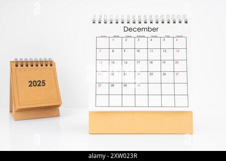 Calendario mensile della scrivania dicembre 2025 anno su tavolo bianco con sfondo bianco. Foto Stock