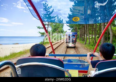Samcheok, Corea del Sud - 29 luglio 2024: I passeggeri si godranno un giro panoramico sulla Samcheok Marine Rail Bike lungo Wonpyeong Beach, con vista costiera Foto Stock